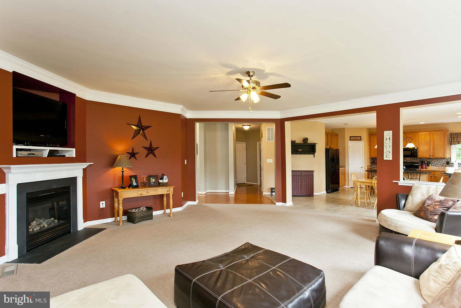 131 Holiday Road Cross Junction, VA 22625 - Photo 7 of 30 a living room with furniture a fireplace and a flat screen tv