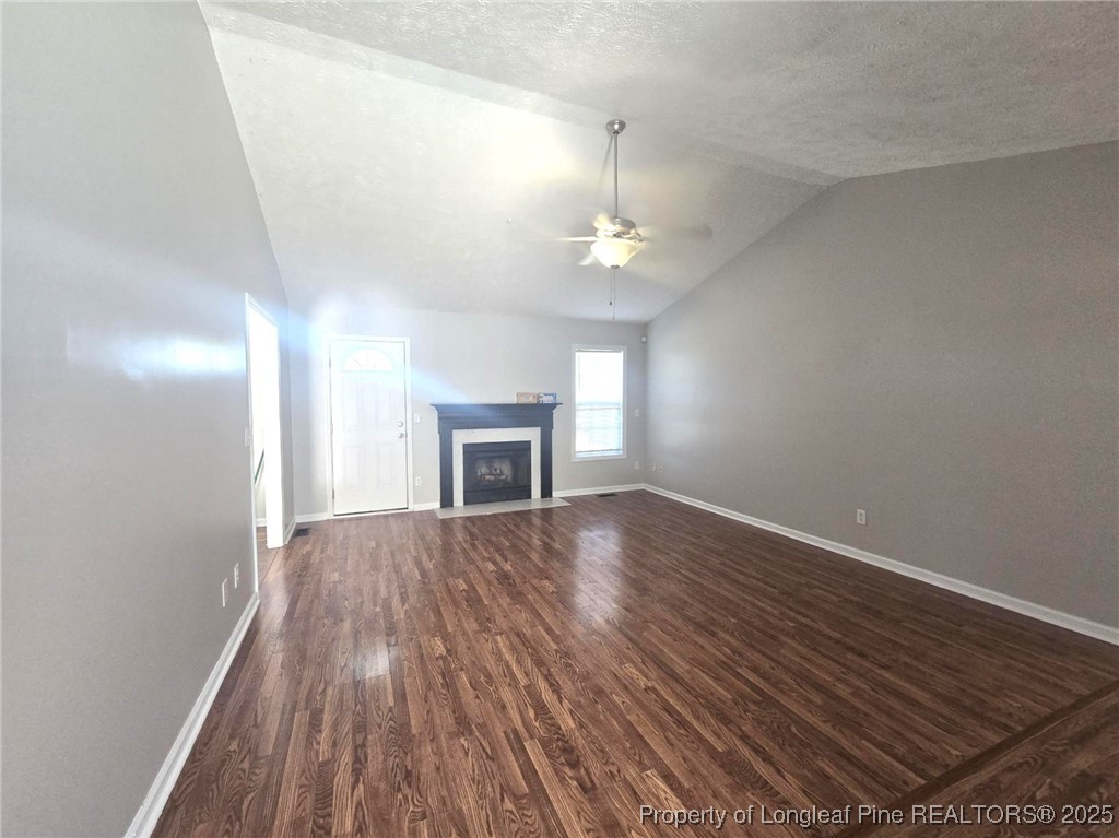 2486 O'Hara Drive Raeford, NC 28376 - Photo 7 of 28 an empty room with wooden floor and fireplace