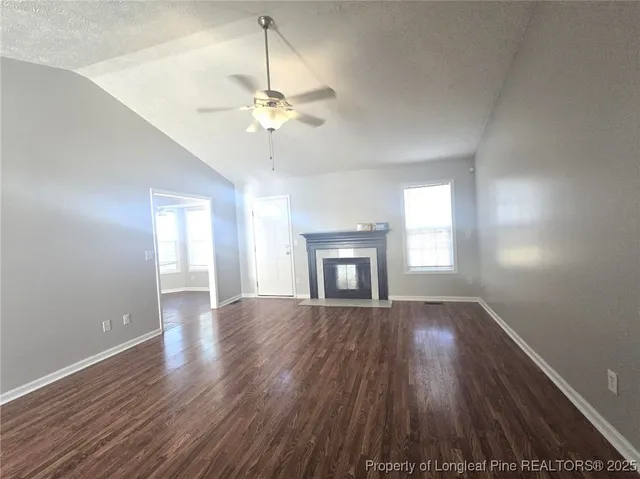a kitchen with granite countertop a stove top oven a sink a refrigerator and white cabinets