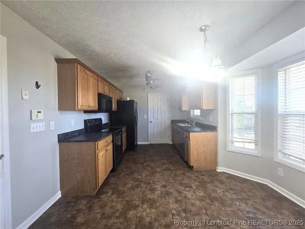 a kitchen with granite countertop a sink a counter top space and stainless steel appliances