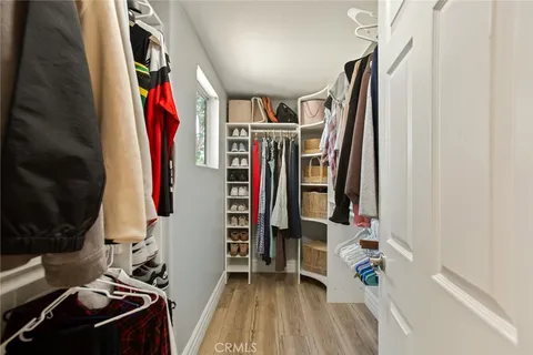a view of walk in closet with clothes and shoes