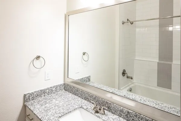 a bathroom with a granite countertop sink and a mirror