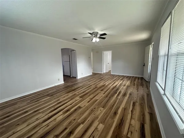 a view of empty room with wooden floor