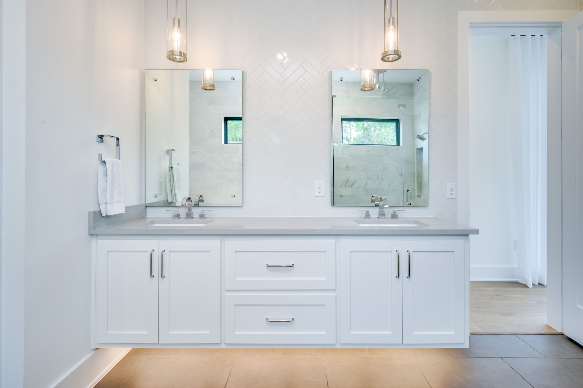2415 McCall Road Austin, TX 78703 - Photo 27 of 40 A well-appointed primary bathroom vanity features dual sinks and contemporary lighting.