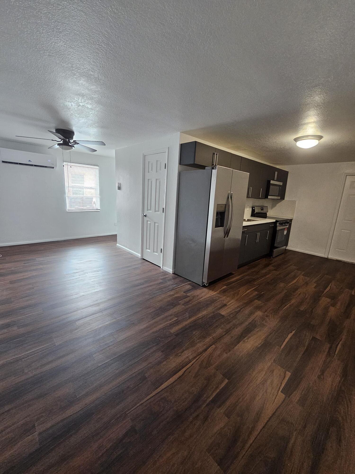 148 West 14th Street, Unit 2 Riviera Beach, FL 33404 - Photo 2 of 6 an empty room with wooden floor and windows