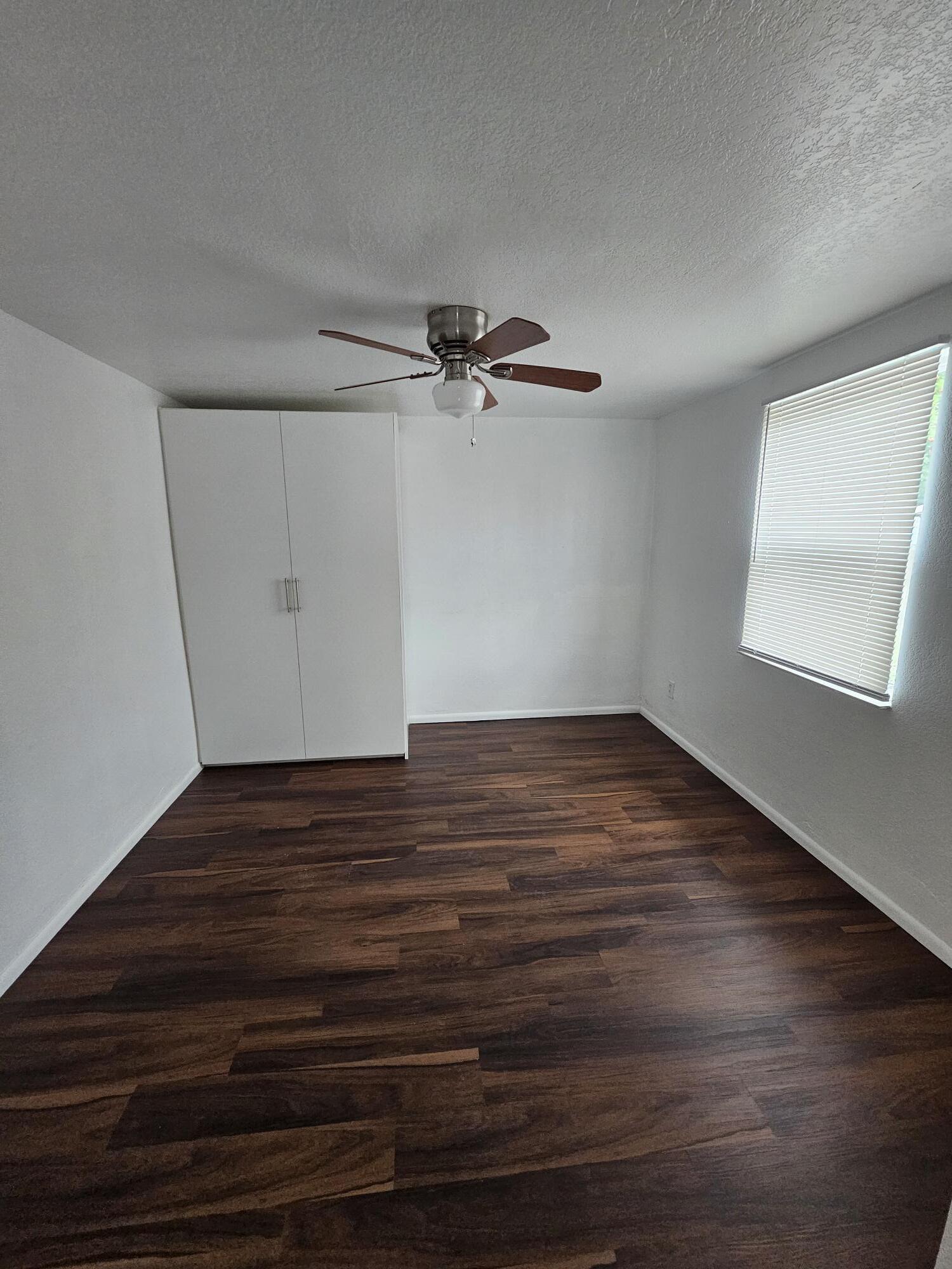 148 West 14th Street, Unit 2 Riviera Beach, FL 33404 - Photo 3 of 6 a view of a room with wooden floor and a ceiling fan