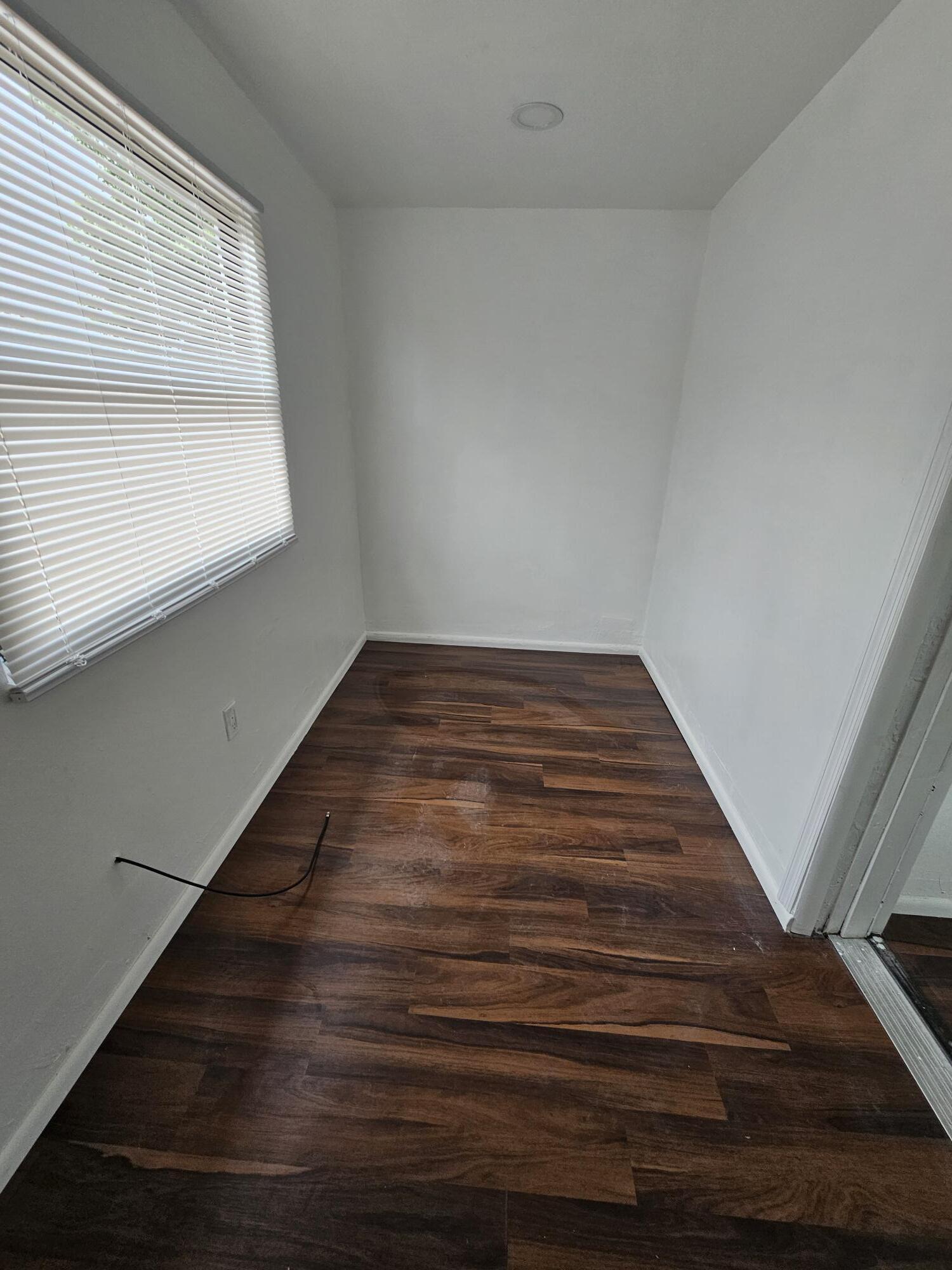 148 West 14th Street, Unit 2 Riviera Beach, FL 33404 - Photo 5 of 6 a view of an empty room with wooden floor and a window