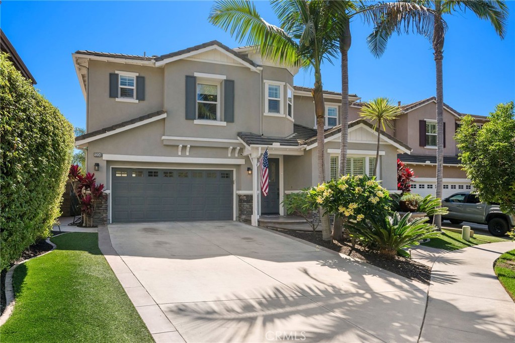 a front view of a house with a garden and palm trees