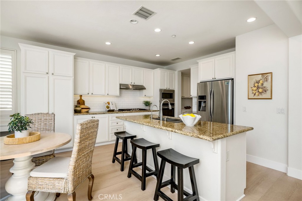 1204 Vista Jardin San Clemente, CA 92673 - Photo 11 of 55 a kitchen with stainless steel appliances granite countertop a refrigerator a stove a sink a dining table and chairs