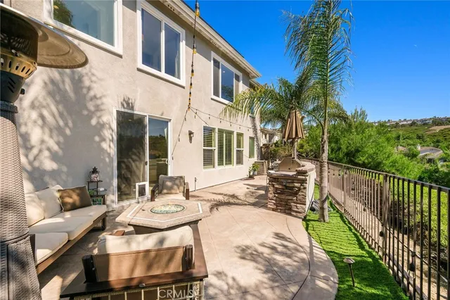a view of a patio with couches potted plants and a palm tree