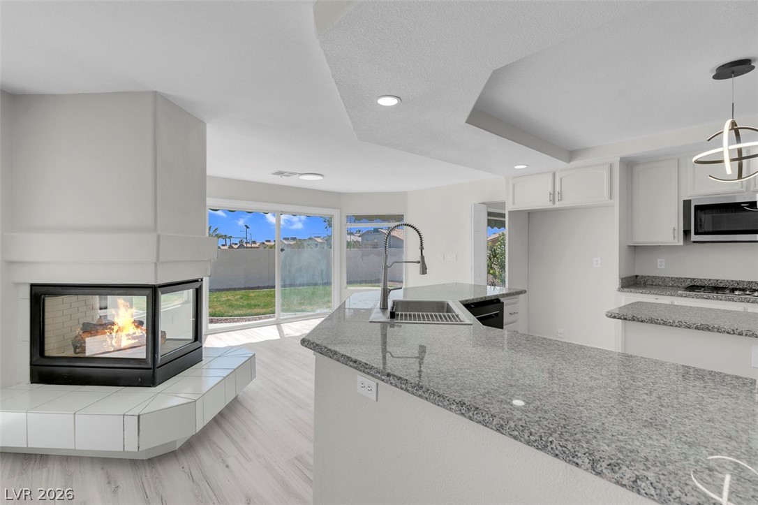 3604 North Campbell Road Las Vegas, NV 89129 - Photo 19 of 54 Kitchen featuring a sink, appliances with stainless steel finishes, light stone counters, white cabinetry, and plenty of natural light