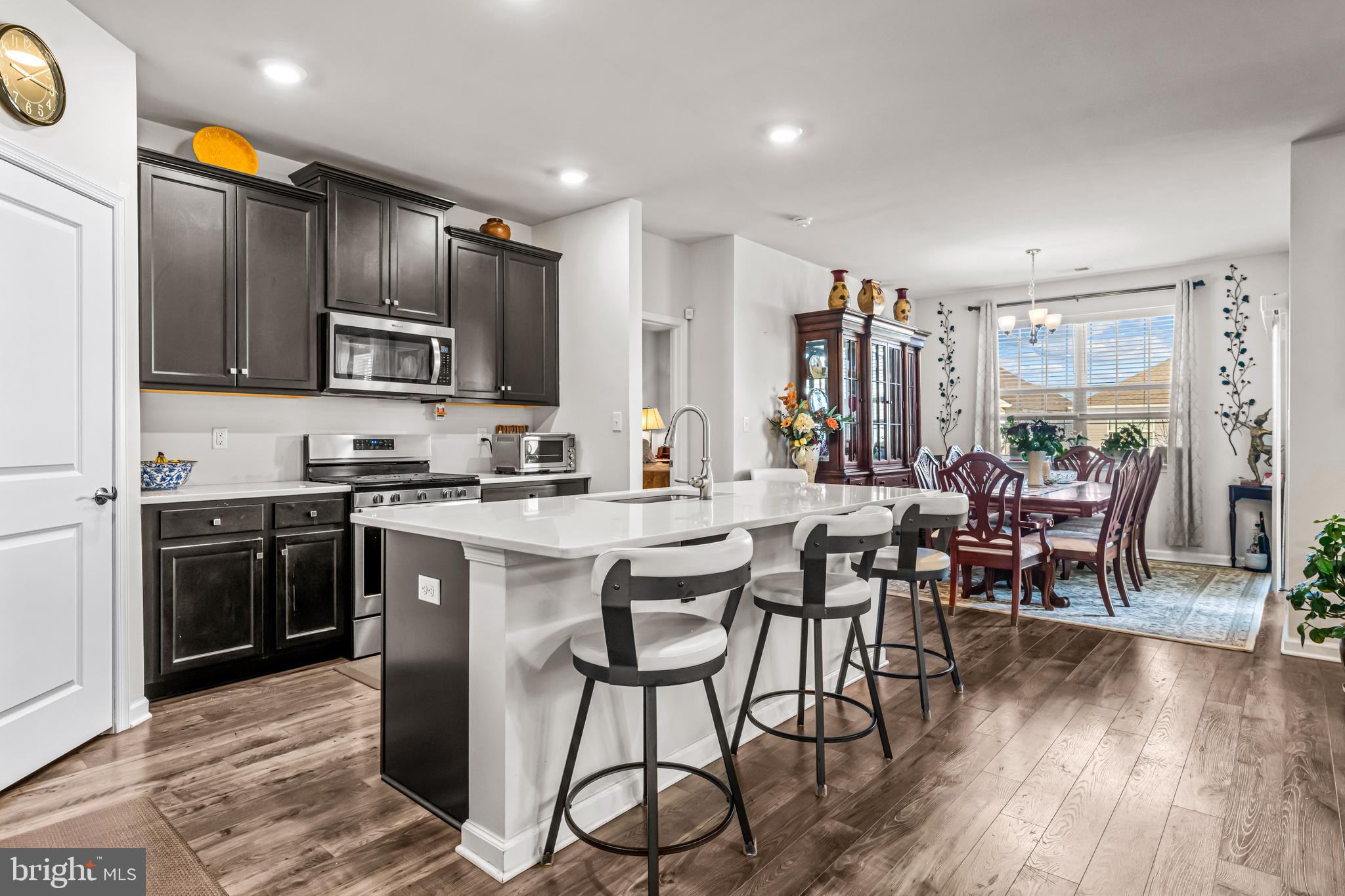 74 Walton Way Delanco, NJ 08075 - Photo 5 of 21 a kitchen with stainless steel appliances granite countertop a stove a refrigerator a kitchen island a dining table and chairs with wooden floor