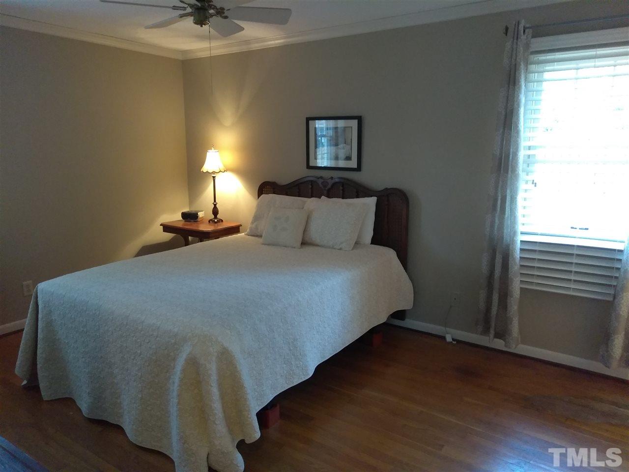 4101 Amherst Lane Raleigh, NC 27609 - Photo 16 of 17 a bedroom with a bed and wooden floor