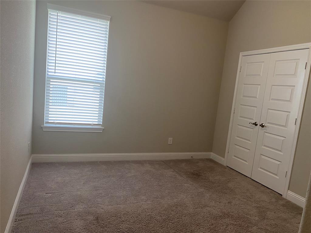 209 Johnson Street Granbury, TX 76048 - Photo 32 of 40 Empty room featuring vaulted ceiling and carpet flooring