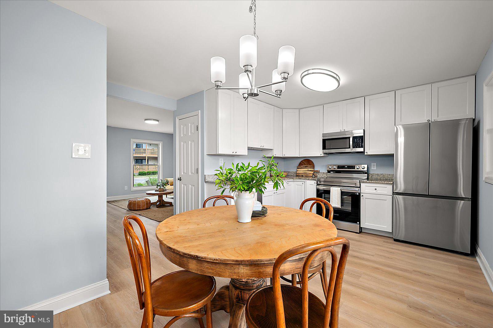 135 Jamestown Road, Unit 18A Ocean City, MD 21842 - Photo 21 of 63 a kitchen with stainless steel appliances a table chairs refrigerator and microwave