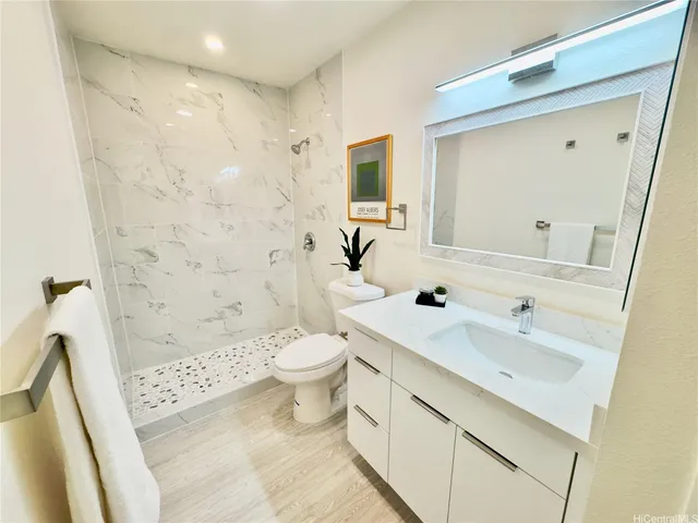 a bathroom with a sink a toilet and shower