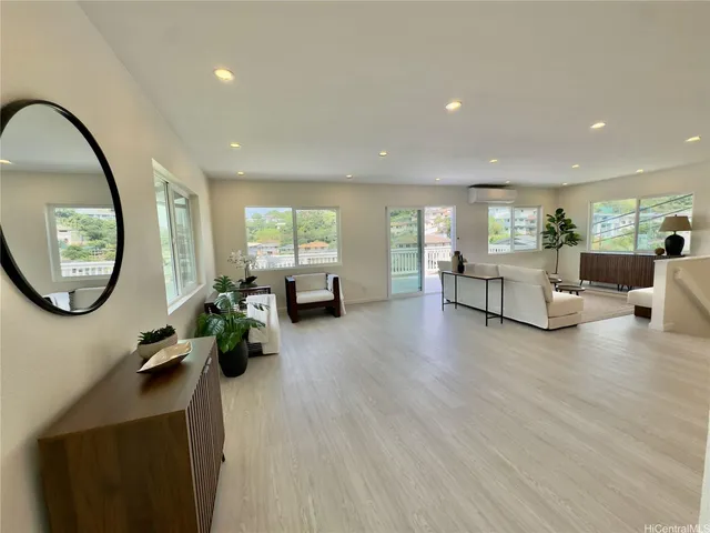 a living room with furniture a mirror and a potted plant