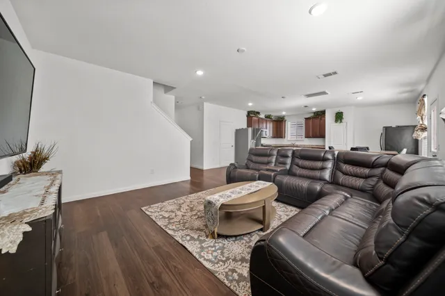 a living room with furniture and wooden floor