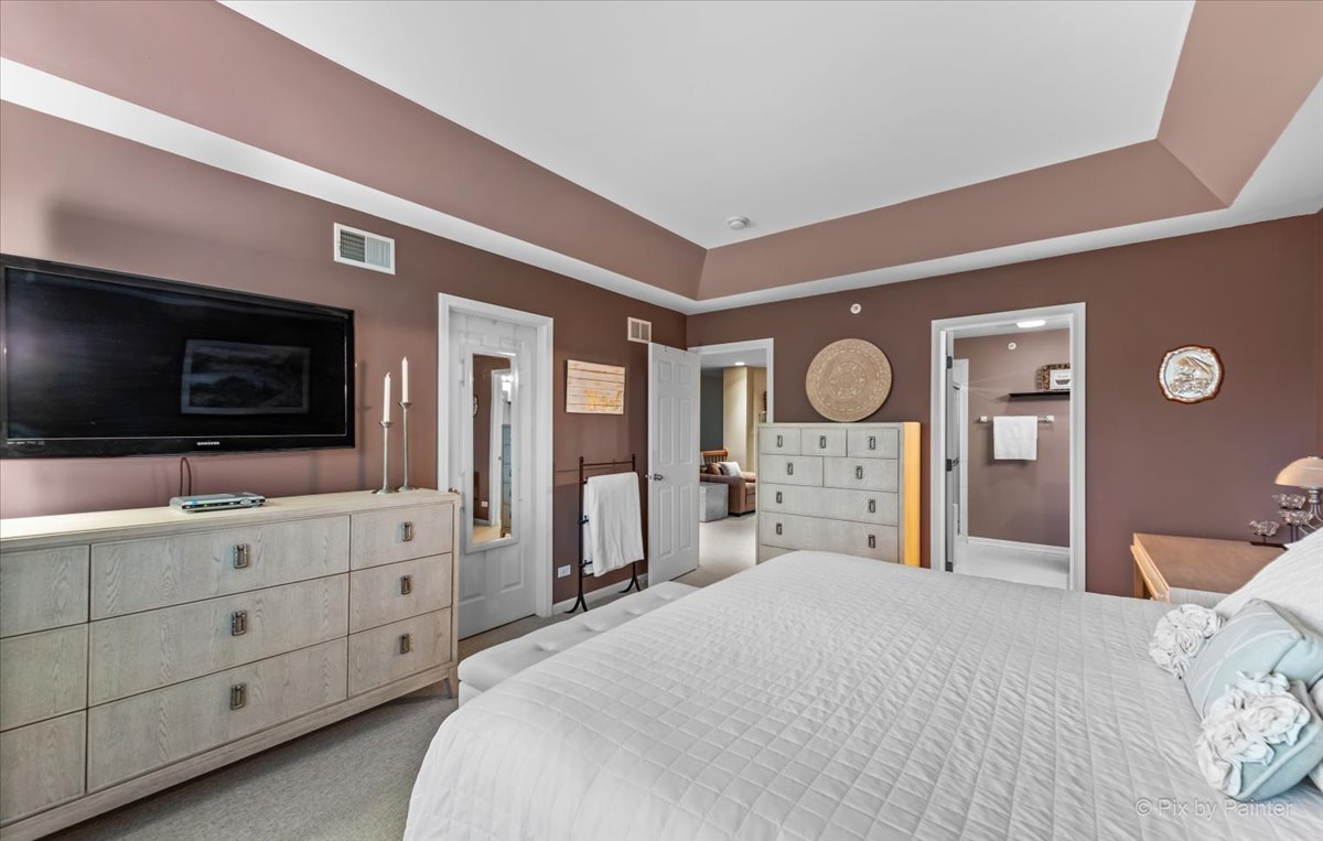 845 Riding Lane St. Charles, IL 60174 - Photo 19 of 32 a spacious bedroom with a bed a mirror and a flat tv screen on dresser