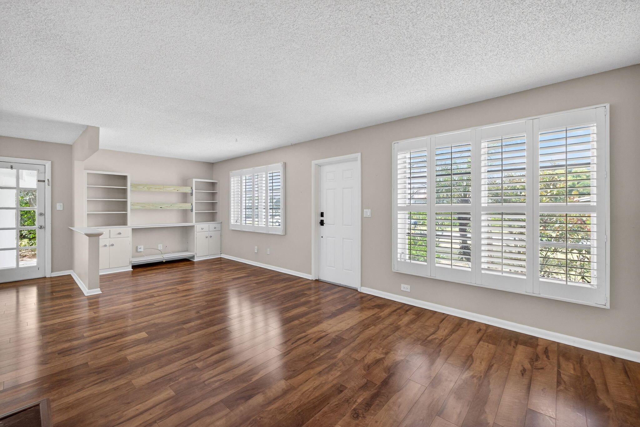 1040 Southeast 5th Street Stuart, FL 34996 - Photo 3 of 21 a view of an empty room with a window and wooden floor