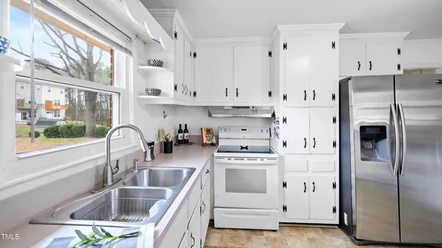 a kitchen with white cabinets and white stainless steel appliances