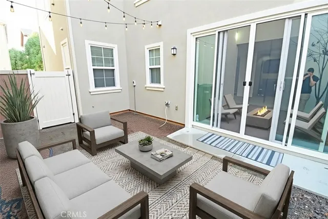 a view of a patio with couches table and chairs and potted plants