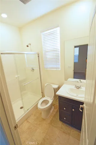 a spacious bathroom with a granite countertop sink toilet a mirror and shower