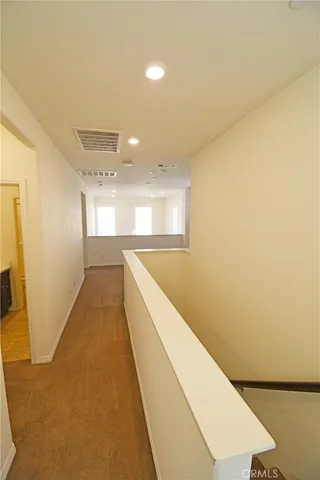a view of a hallway with wooden floor and staircase