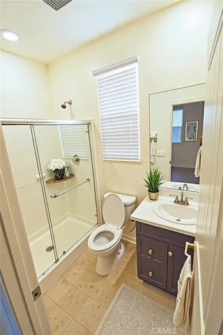 a spacious bathroom with a granite countertop toilet sink and mirror