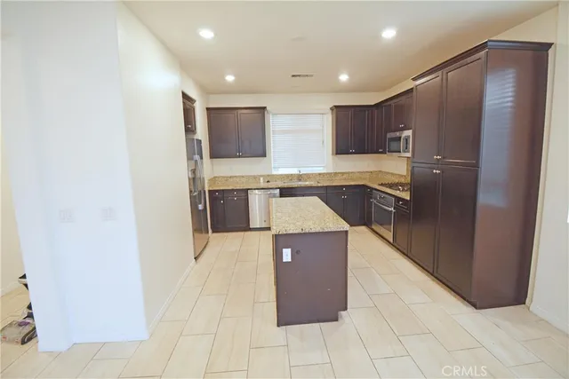 a kitchen with kitchen island cabinets and refrigerator