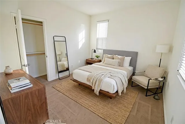 a bedroom with a bed wooden floor and a mirror