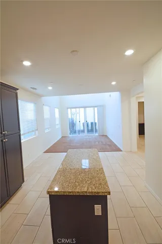 a kitchen with granite countertop sink and refrigerator