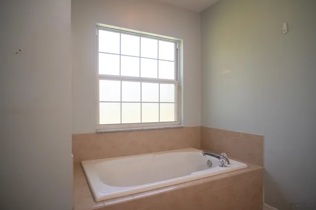 en empty room with windows and chandelier fan