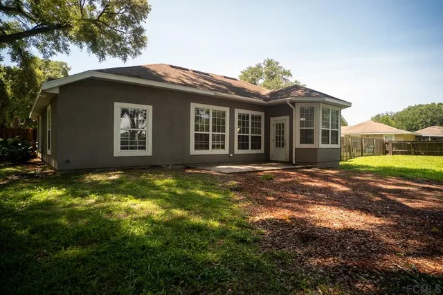 a view of a house with backyard and a tree