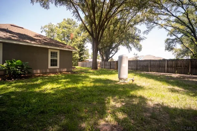 a front view of house with yard and trees in the background