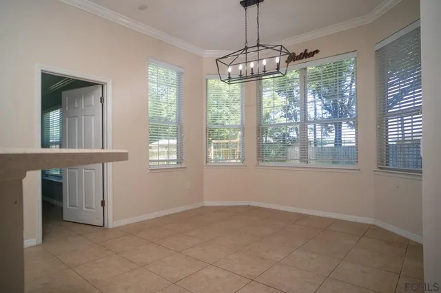 a view of an empty room with a window and chandelier