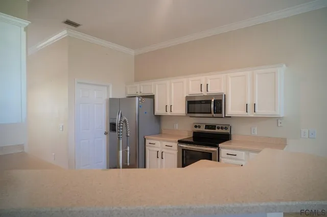 a kitchen with stainless steel appliances a refrigerator stove and microwave