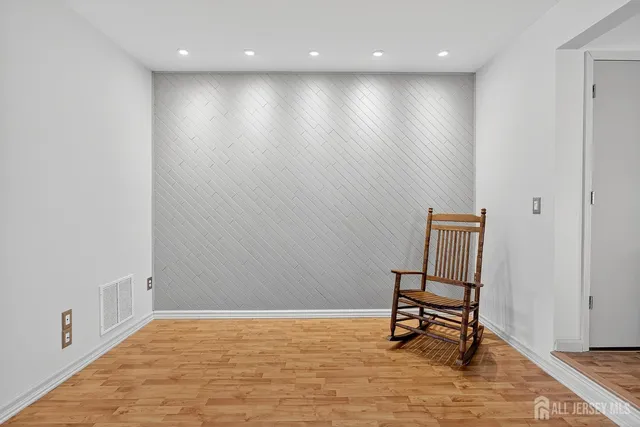 a view of a room with wooden floor and bench
