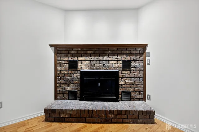 an empty room with windows and fireplace