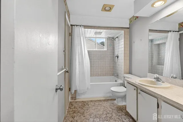 a bathroom with a granite countertop toilet sink and mirror