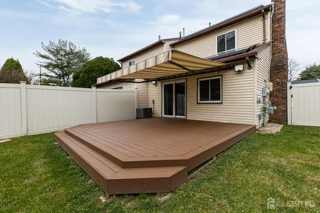 a view of a white house with a yard and plants