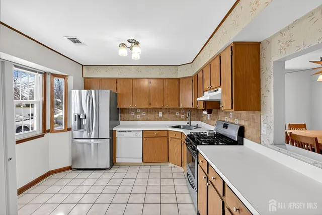a kitchen with a refrigerator a sink and cabinets