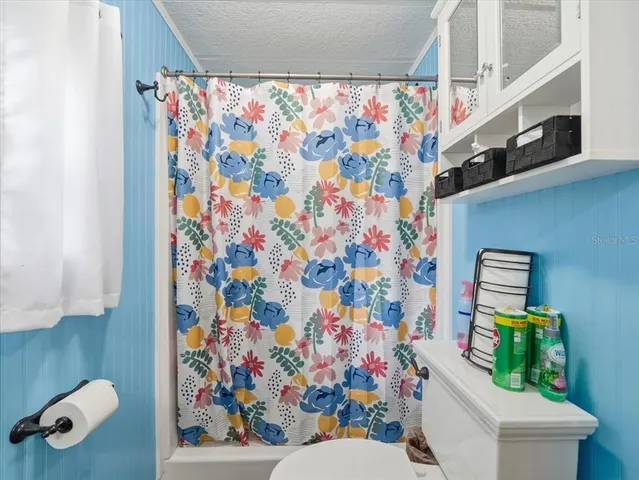 a bathroom with a toilet and a shower curtain
