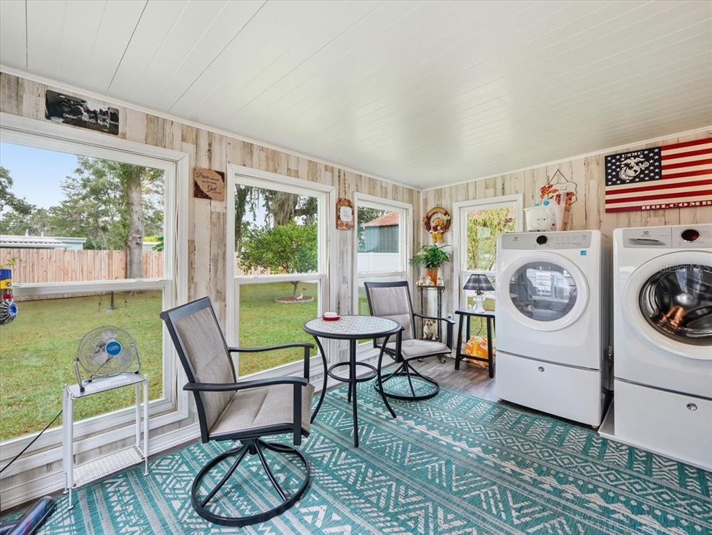 1422 North Reed Terrace Inverness, FL 34453 - Photo 26 of 39 a living room with furniture a fireplace and a floor to ceiling window