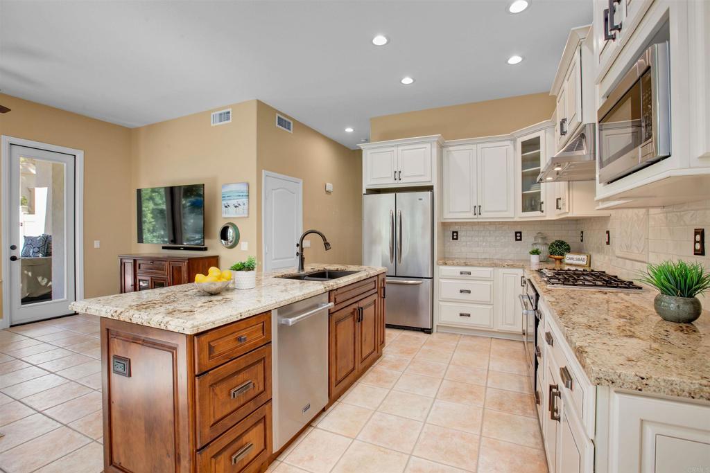 7159 Tanager Drive Carlsbad, CA 92011 - Photo 14 of 68 a kitchen with a stove a sink a refrigerator and a refrigerator