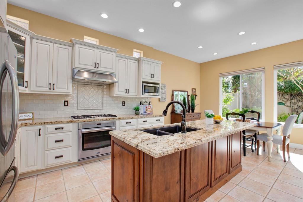 7159 Tanager Drive Carlsbad, CA 92011 - Photo 16 of 68 a kitchen with granite countertop a sink a stove and cabinets