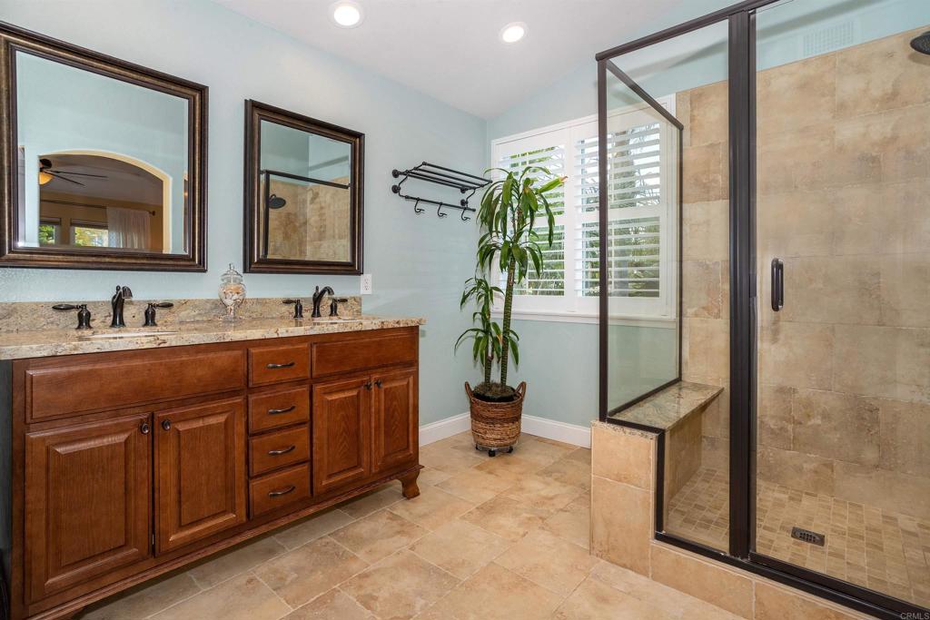 7159 Tanager Drive Carlsbad, CA 92011 - Photo 35 of 68 a spacious bathroom with a double vanity sink a mirror and a shower