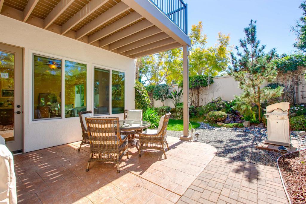 7159 Tanager Drive Carlsbad, CA 92011 - Photo 42 of 68 a view of a patio with a dining table and chairs with wooden floor and fence