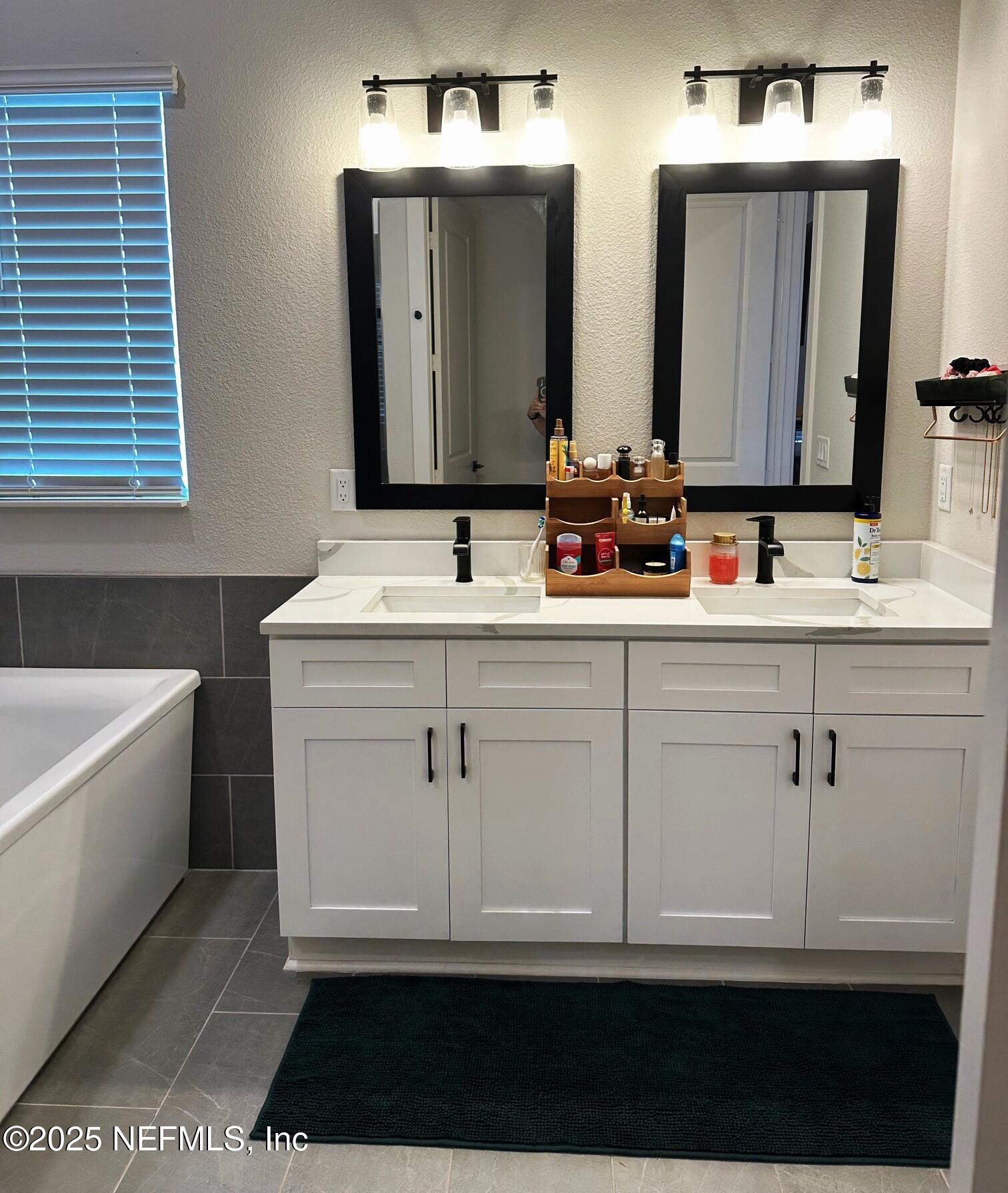 36079 Pitch Lane Hilliard, FL 32046 - Photo 16 of 35 a bathroom with a double vanity sink and mirror