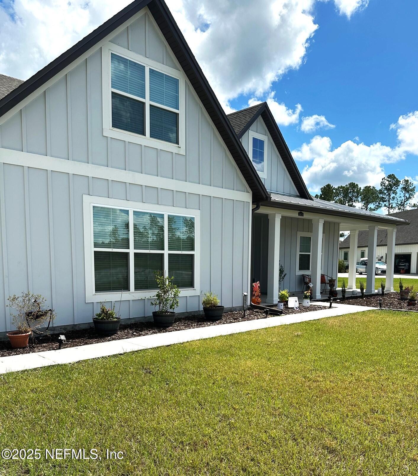 36079 Pitch Lane Hilliard, FL 32046 - Photo 3 of 35 a front view of a house with a garden and patio
